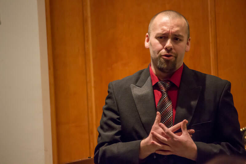 Close-up of Connor Gibbs singing with a smirk.