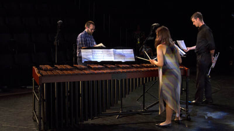 Connor rehearses with a marimba and trumpet player for one of his pieces.