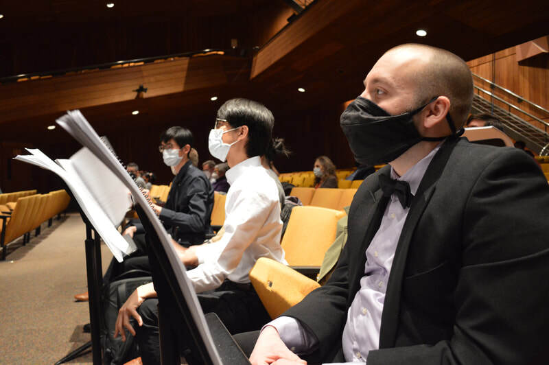 Connor sits in the audience with other composers.