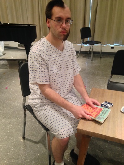 Connor Gibbs sitting in a hospital gown costume.