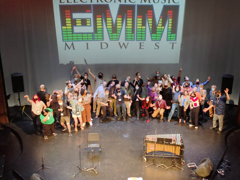 Large group of composers at Electronic Music Midwest 2022, making comical expressions.