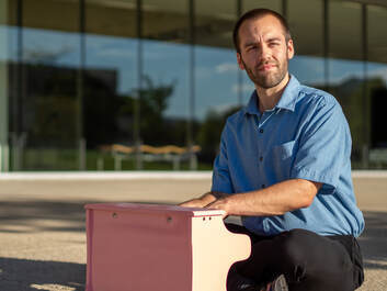 Connor playing a toy piano while looking into the sun.