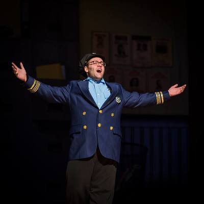 Connor Gibbs singing passionately as a police officer.